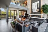 Luxury open living remodel with fireplace, piano, glass rail, and custom built-ins.