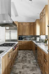 White kitchen cabinetry with brass pulls, white tile backsplash, and styled countertop detail.