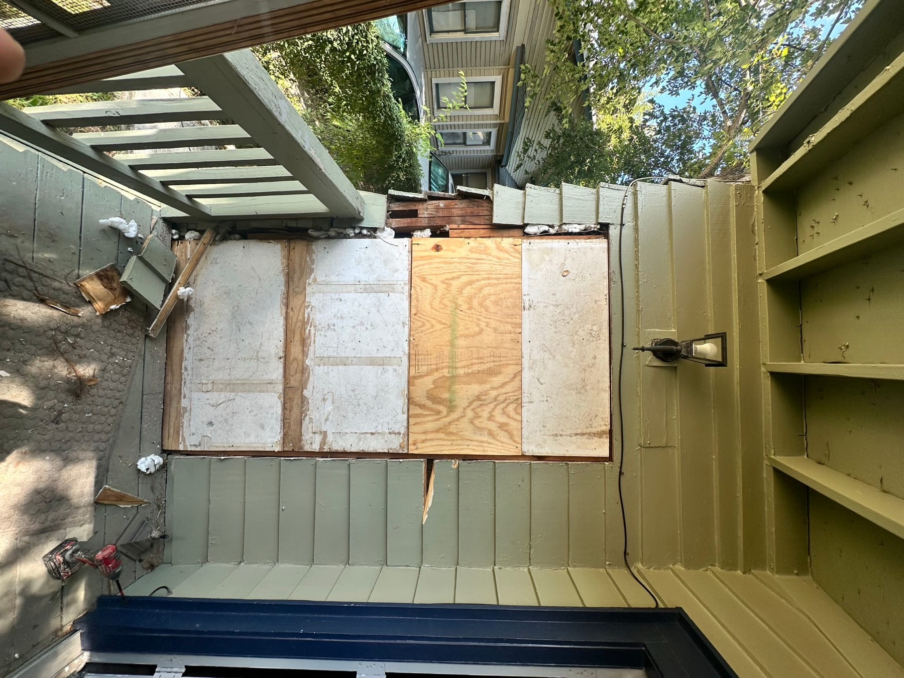 Porch wall opening covered with plywood before exterior siding repair.