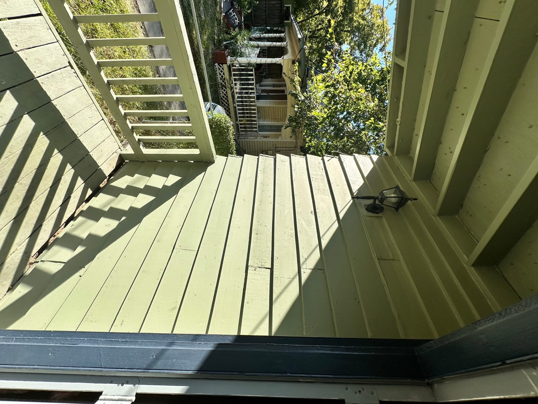Porch wall and siding after exterior wall repair beside a railing.