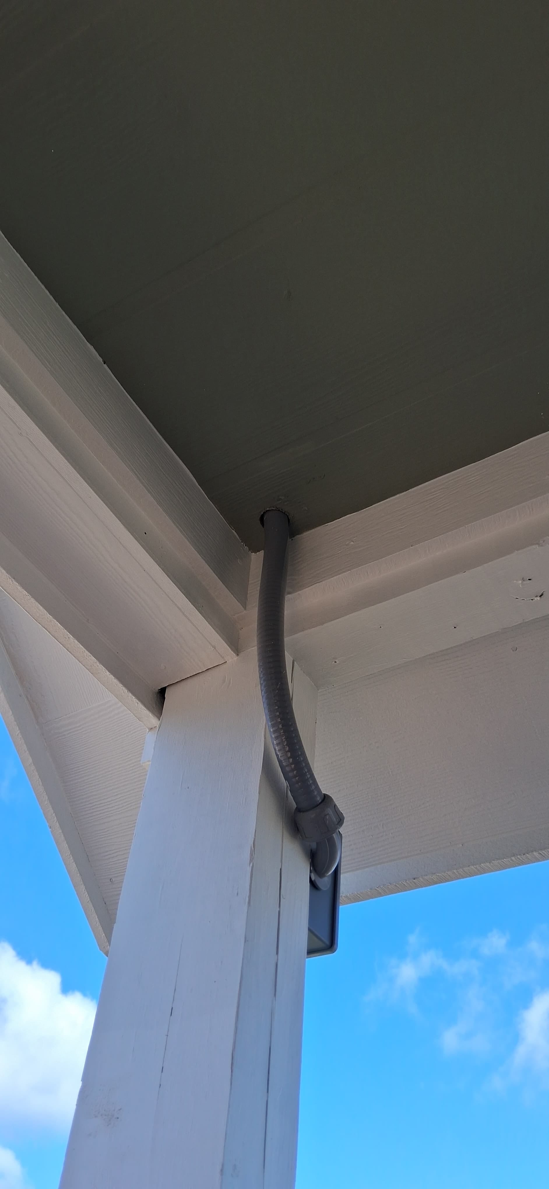 Close view of painted trim and roofline detail on a small exterior structure.