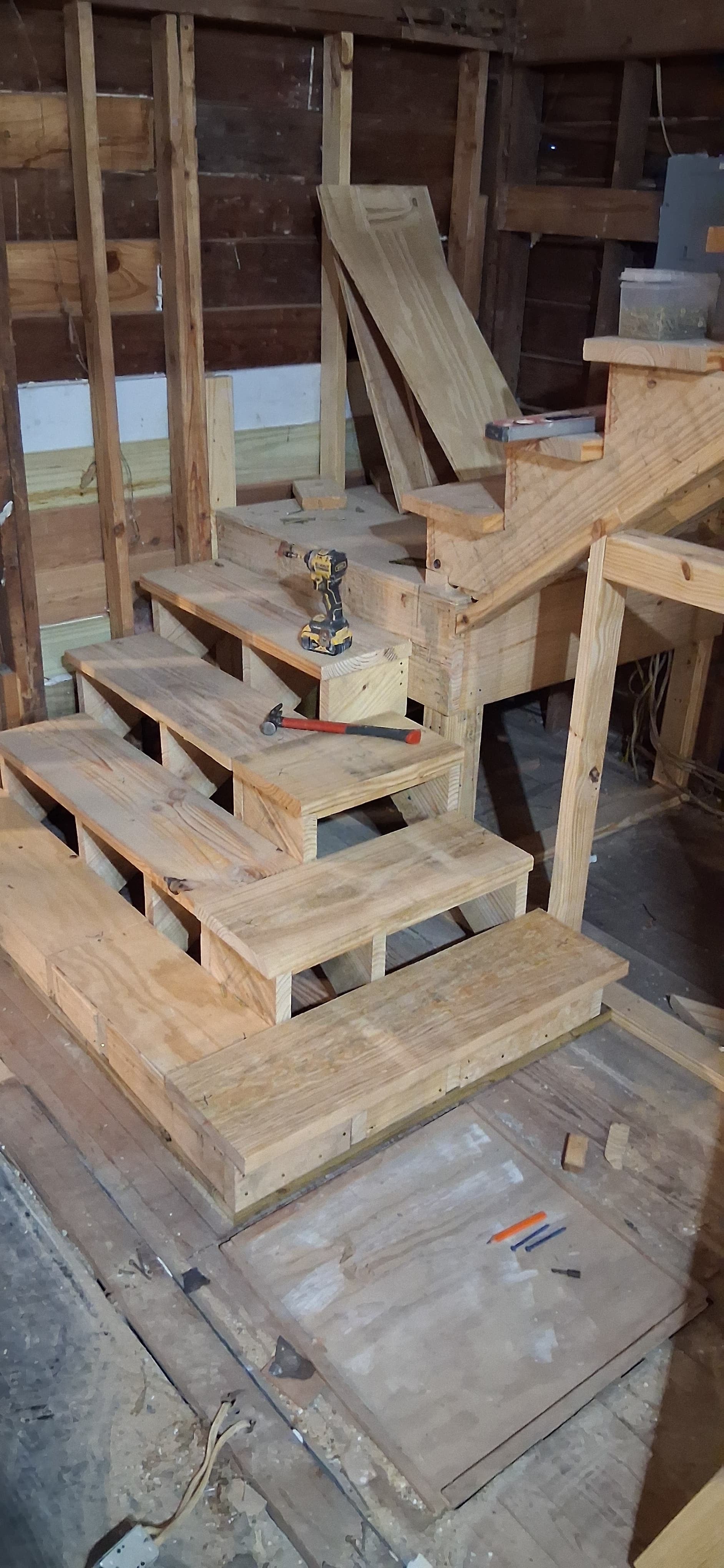Newly framed wood stairs inside a construction space before finish materials are installed.
