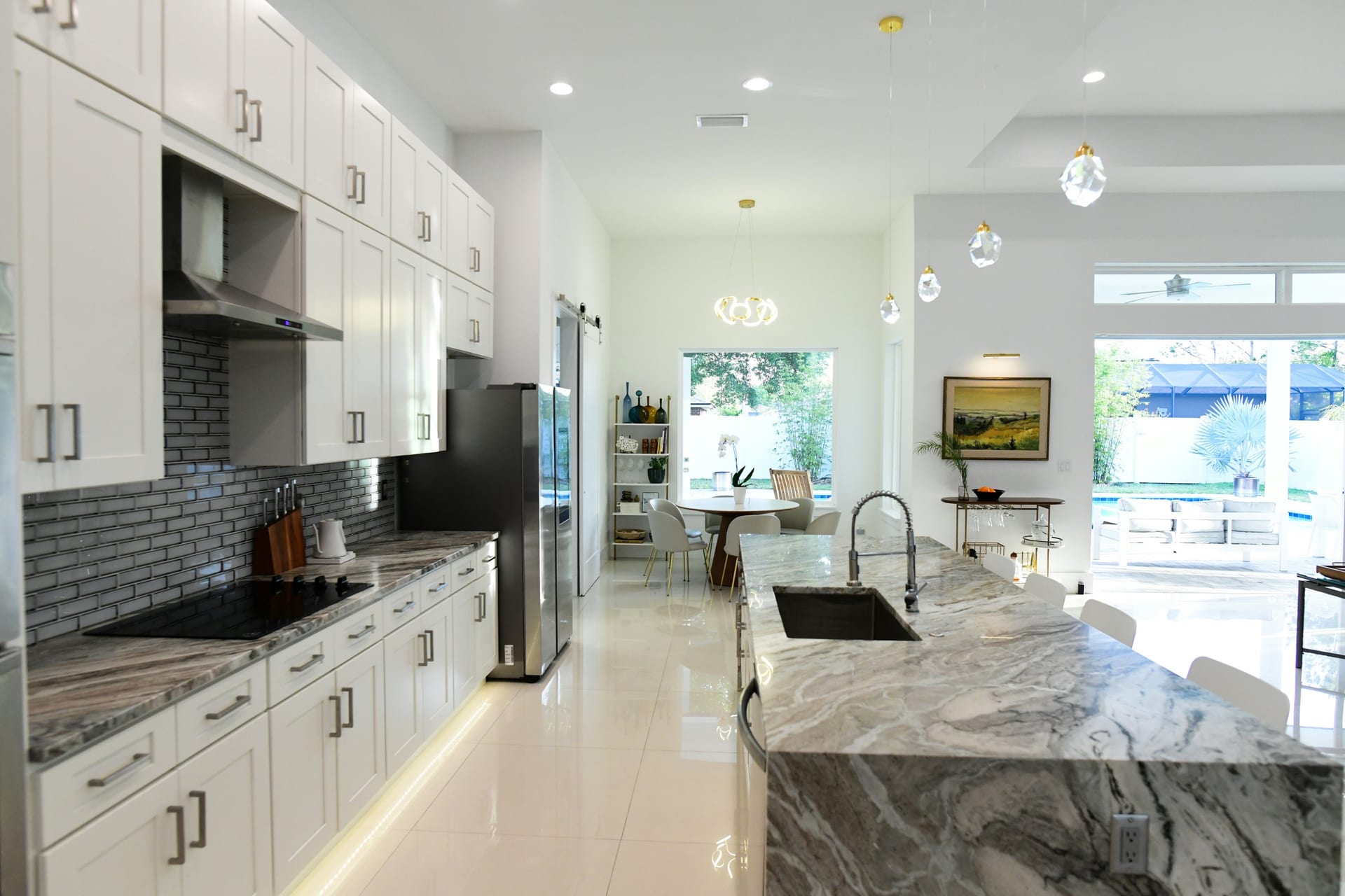 Bright kitchen remodel with warm wood cabinetry, white countertops, tile backsplash, and windows bringing in natural light.