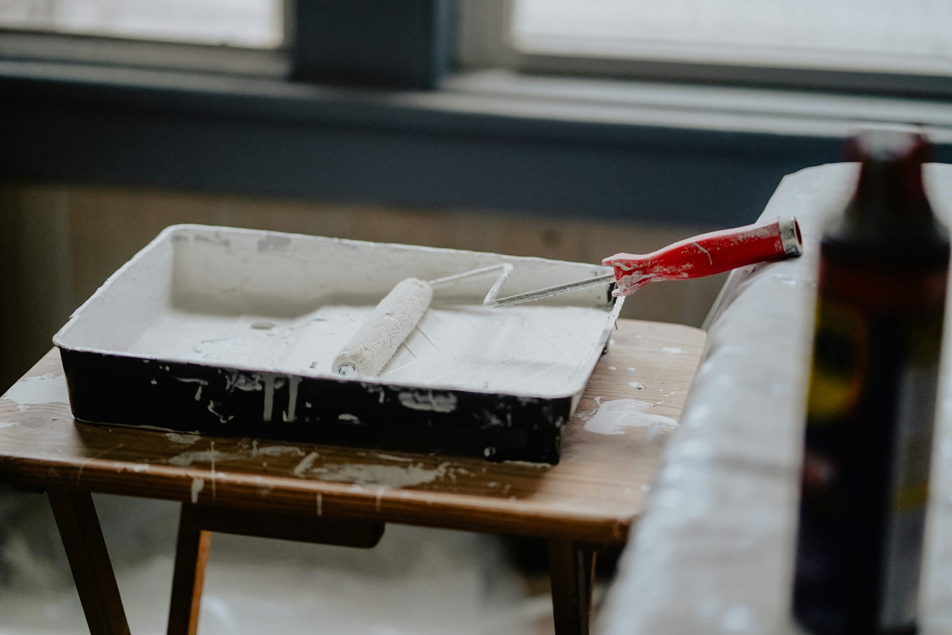 Paint tray and roller staged near a window during touch-up work.